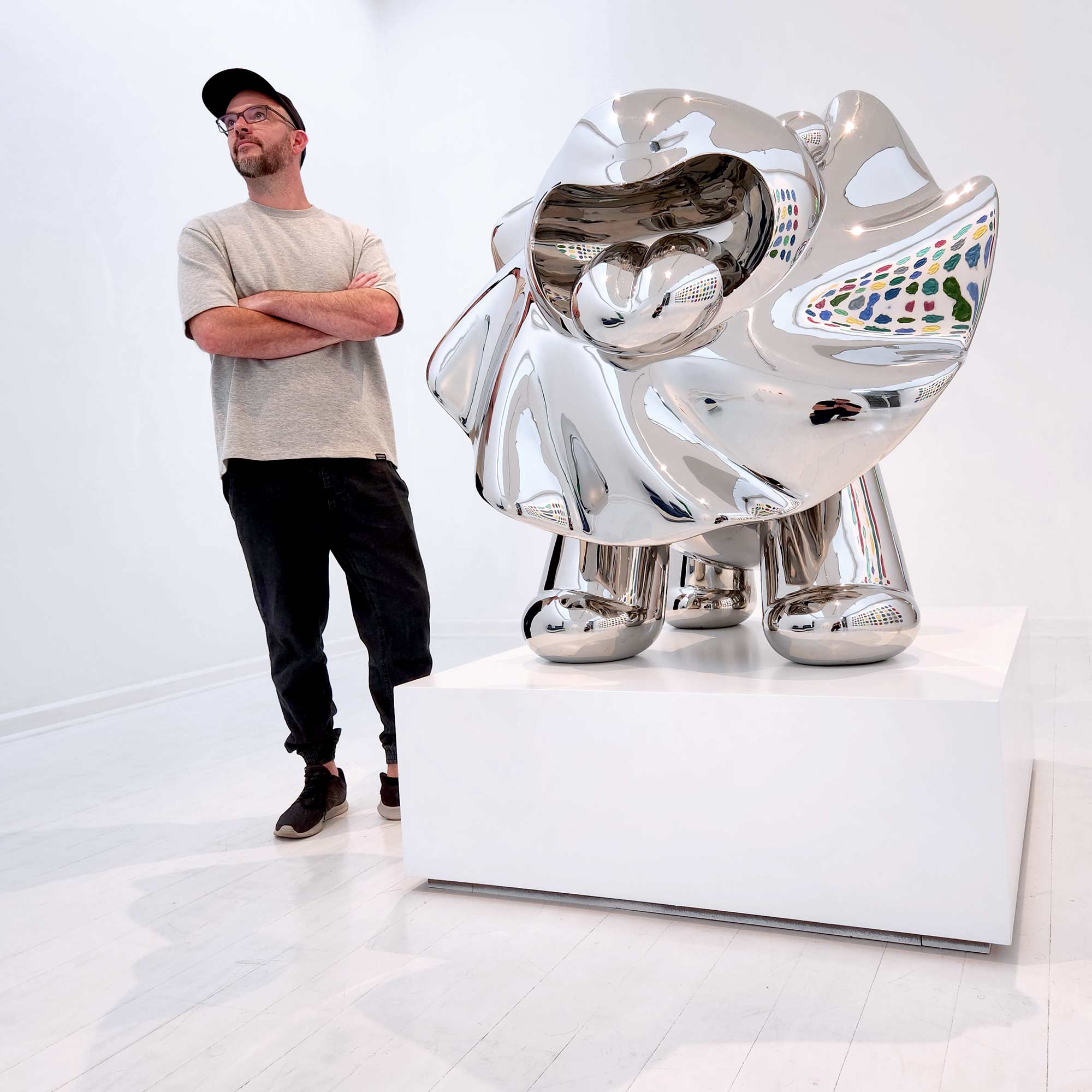 Lions breath polished stainless steel sculpture large size by Ferdi B Dick , artist standing next to lion sculpture