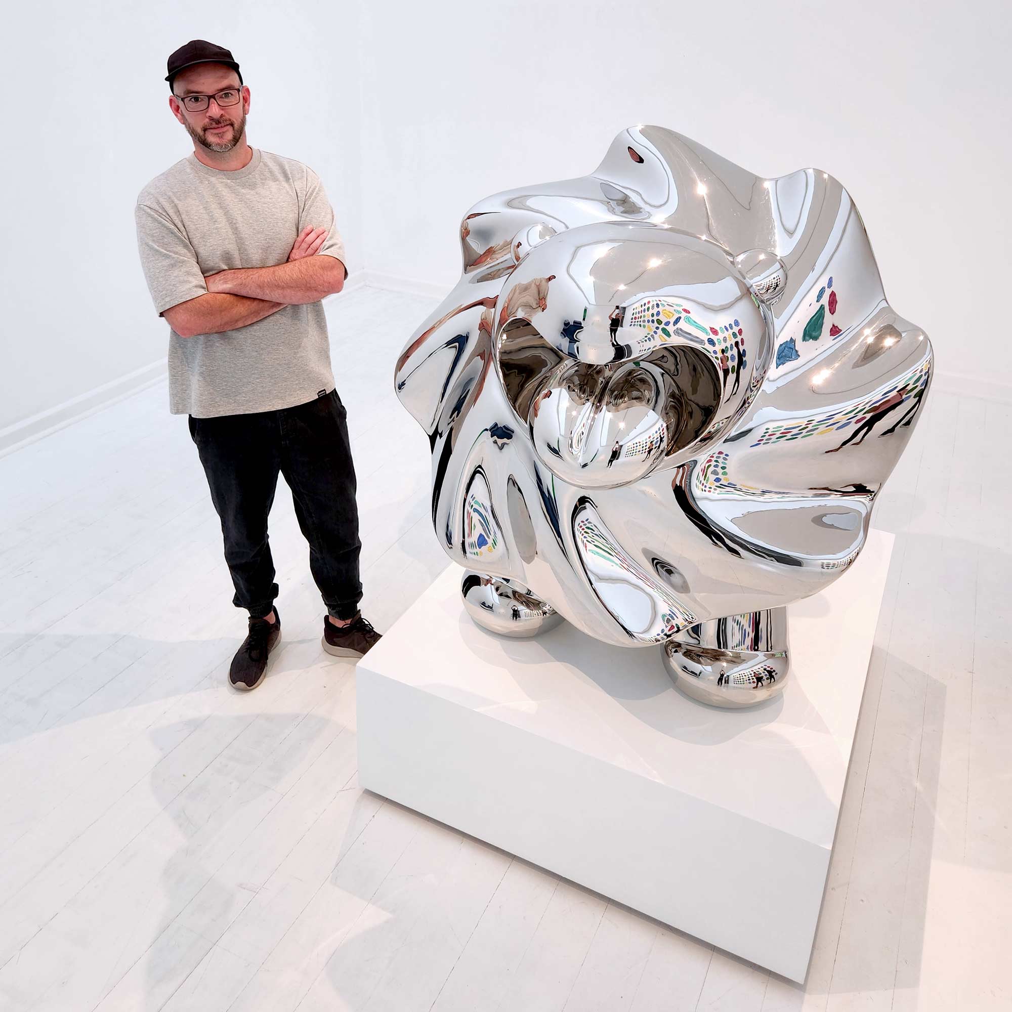 Lions breath stainless steel sculpture with Ferdi B Dick the artist standing next to sculpture
