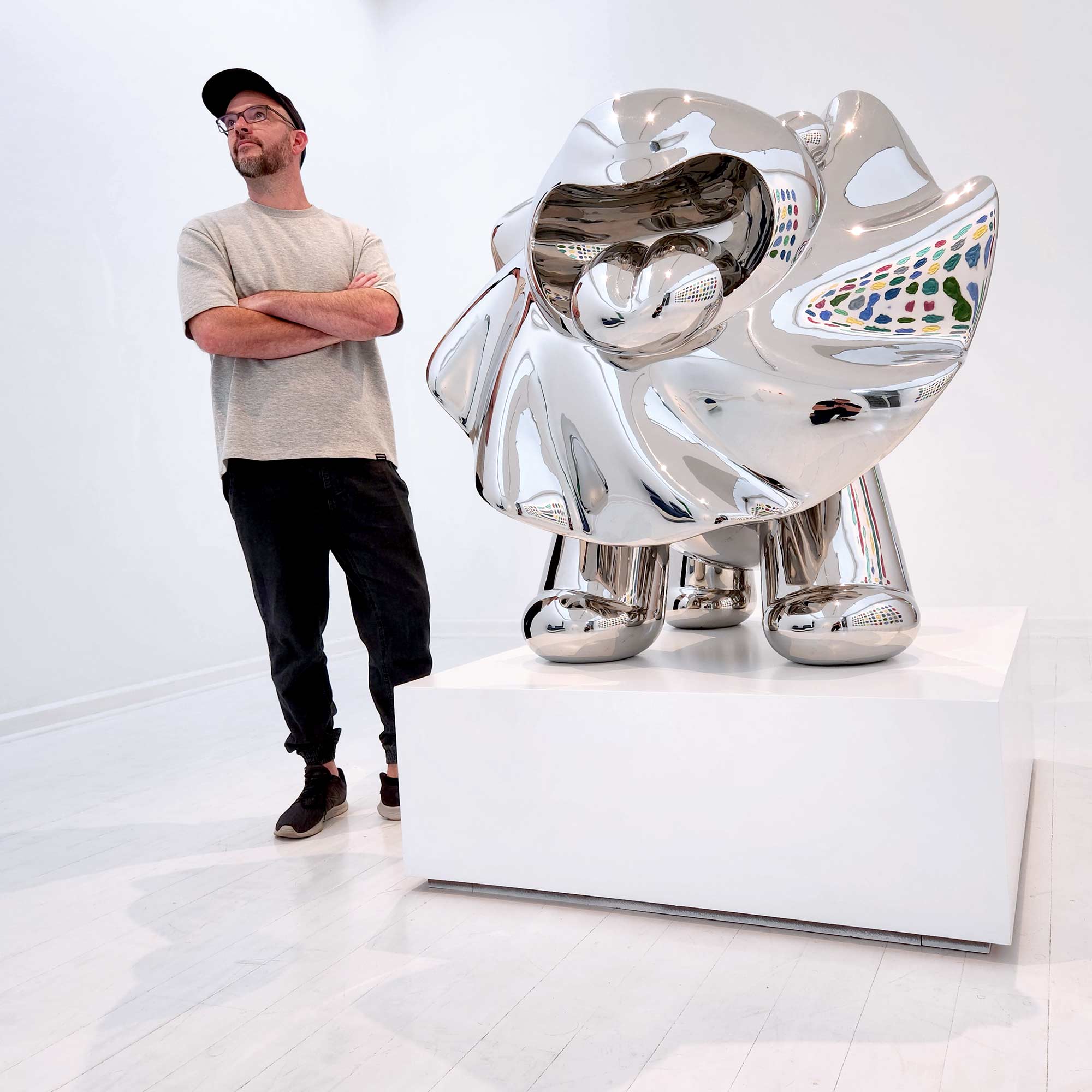 Lions breath polished stainless steel sculpture large size by Ferdi B Dick , artist standing next to lion sculpture 